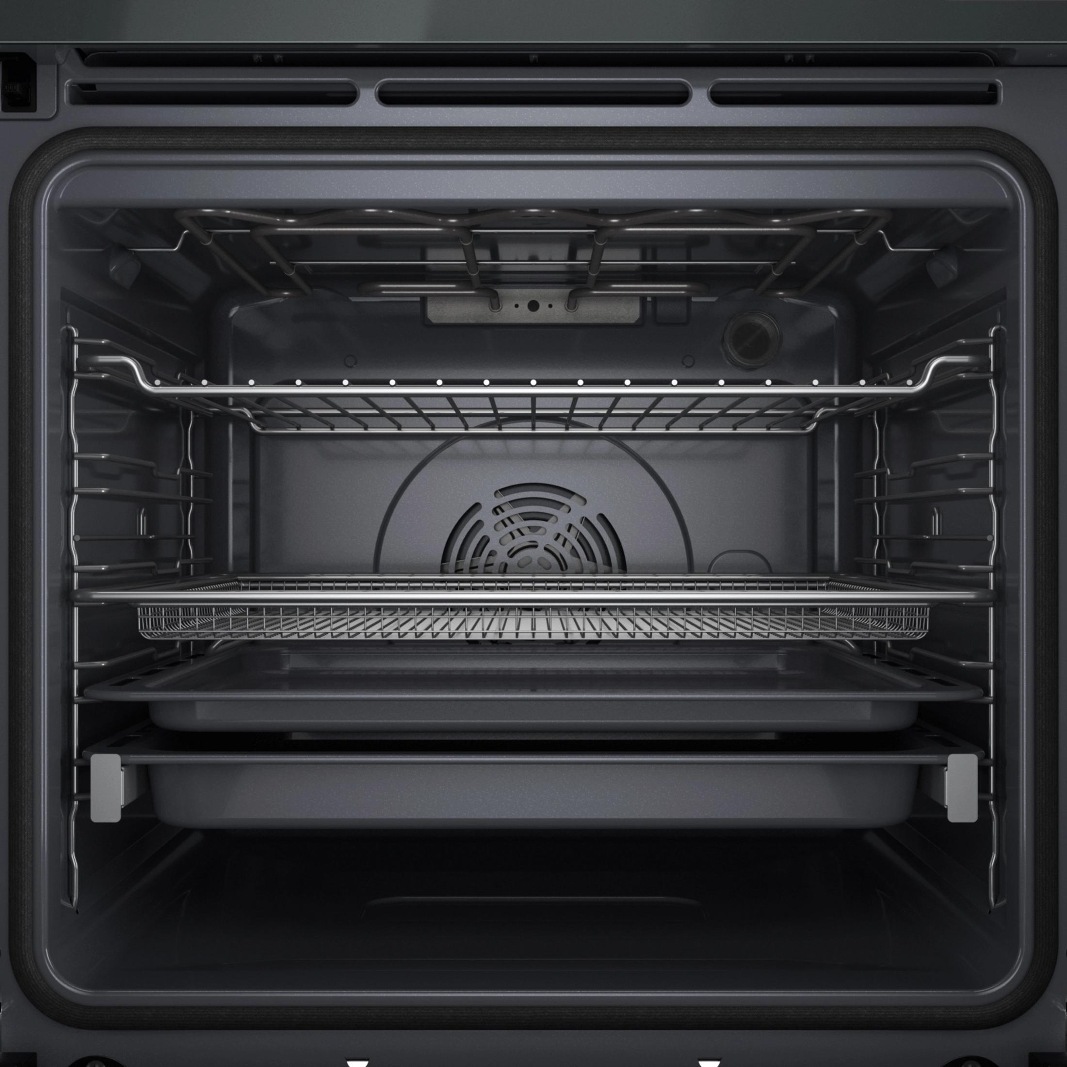 Vista interna di un forno pulito e moderno con tre griglie e due teglie.