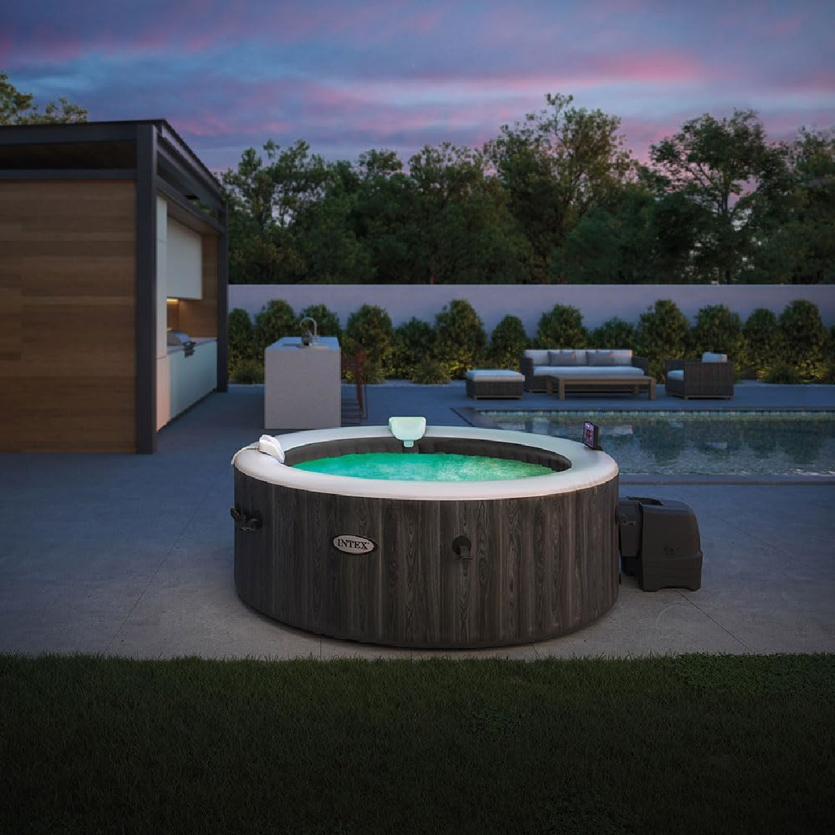 Aufblasbarer Whirlpool mit Holzmaserung neben einem Pool und Sitzbereich bei Dämmerung.