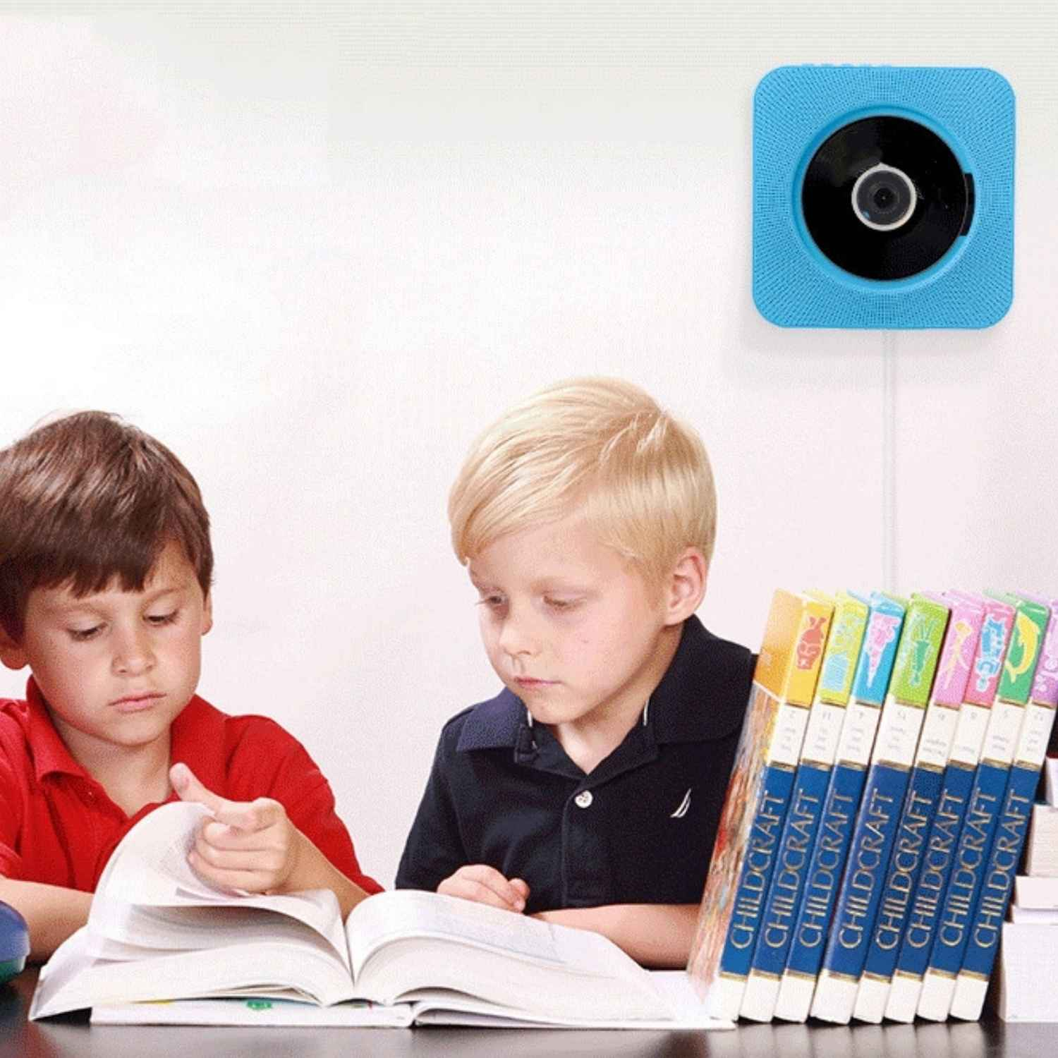 Zwei Jungen lesen Bücher vor einem blauen CD-Player an der Wand.