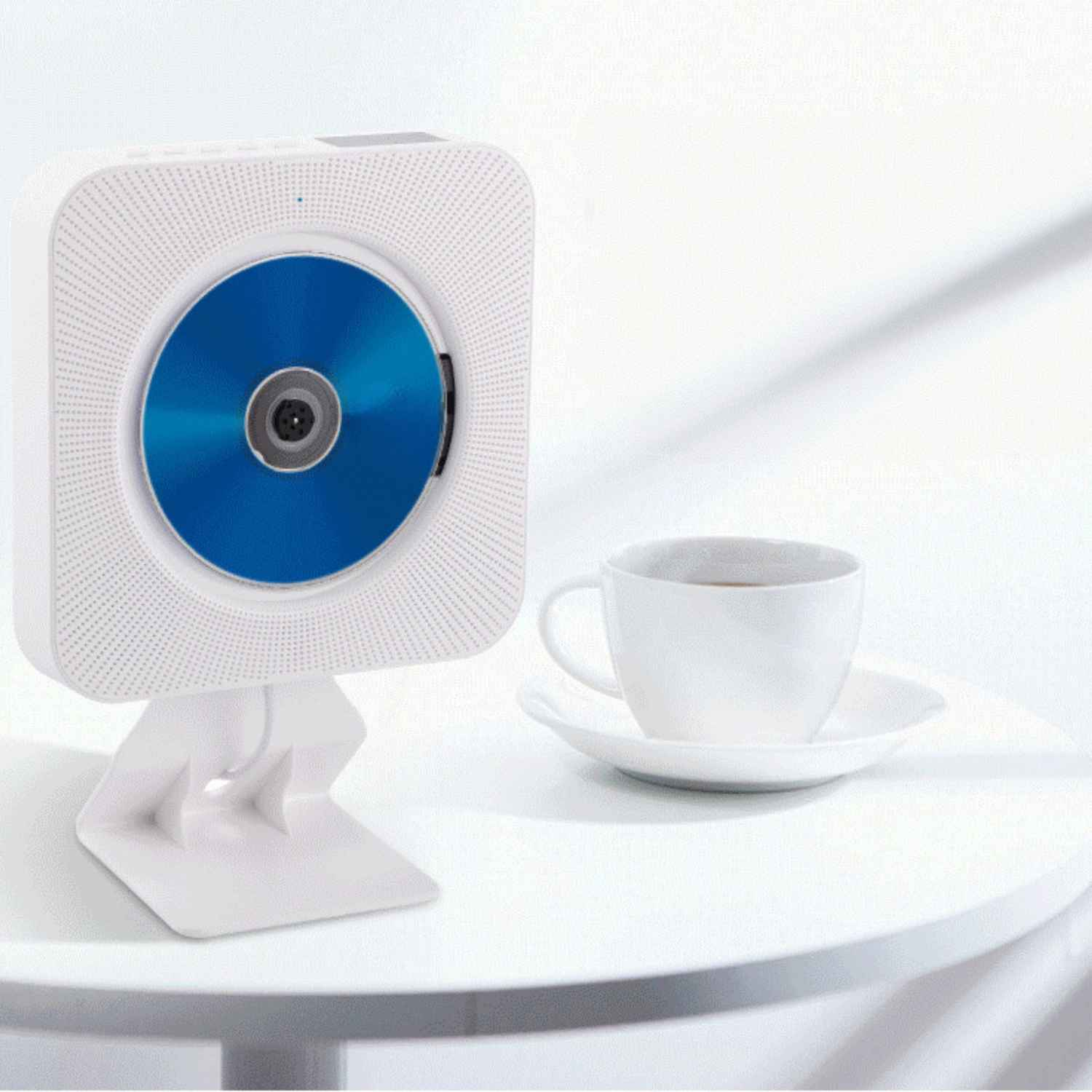Ein weißer CD-Player mit blauer CD, daneben eine weiße Tasse Kaffee.