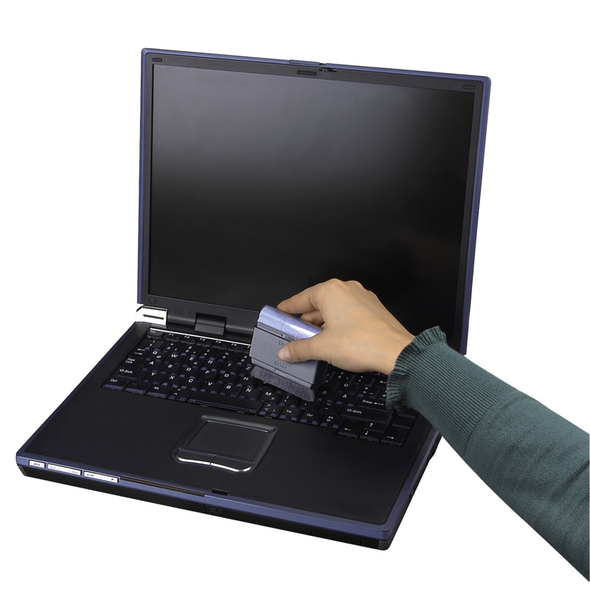 Una mano pulisce una tastiera per laptop con una spazzola.