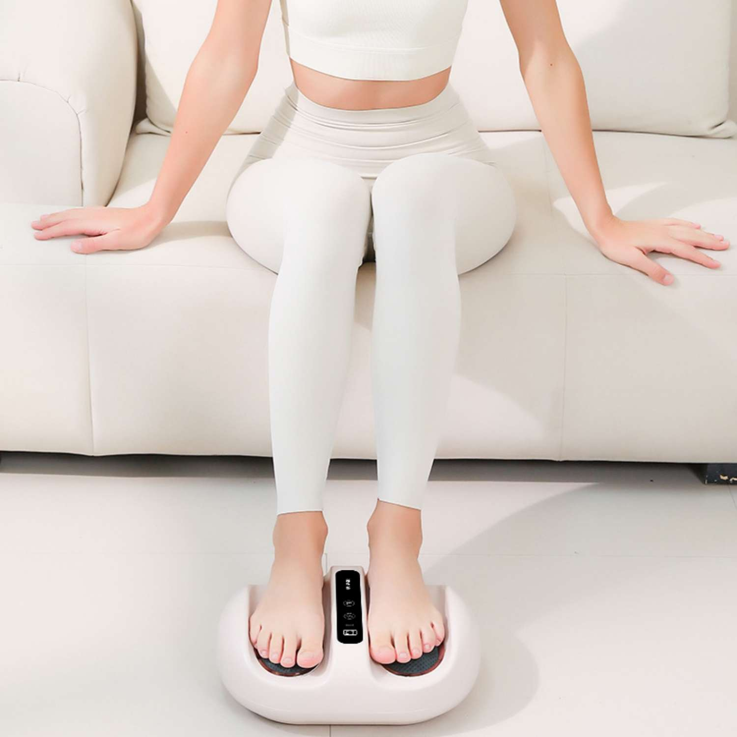 Eine Person sitzt auf einem Sofa und benutzt einen Fußmassagegerät.