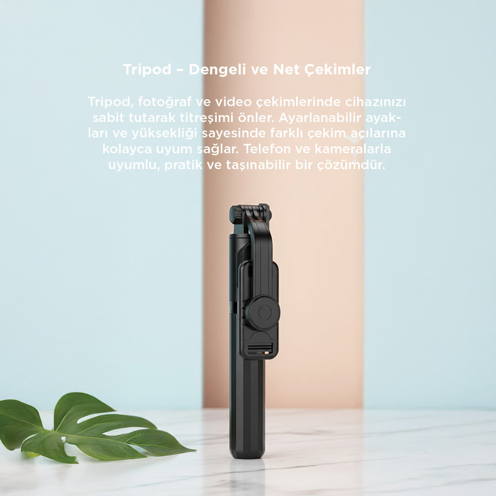 Ön planda mermer üzerinde açık yapraklı siyah selfie çubuğu tripod.