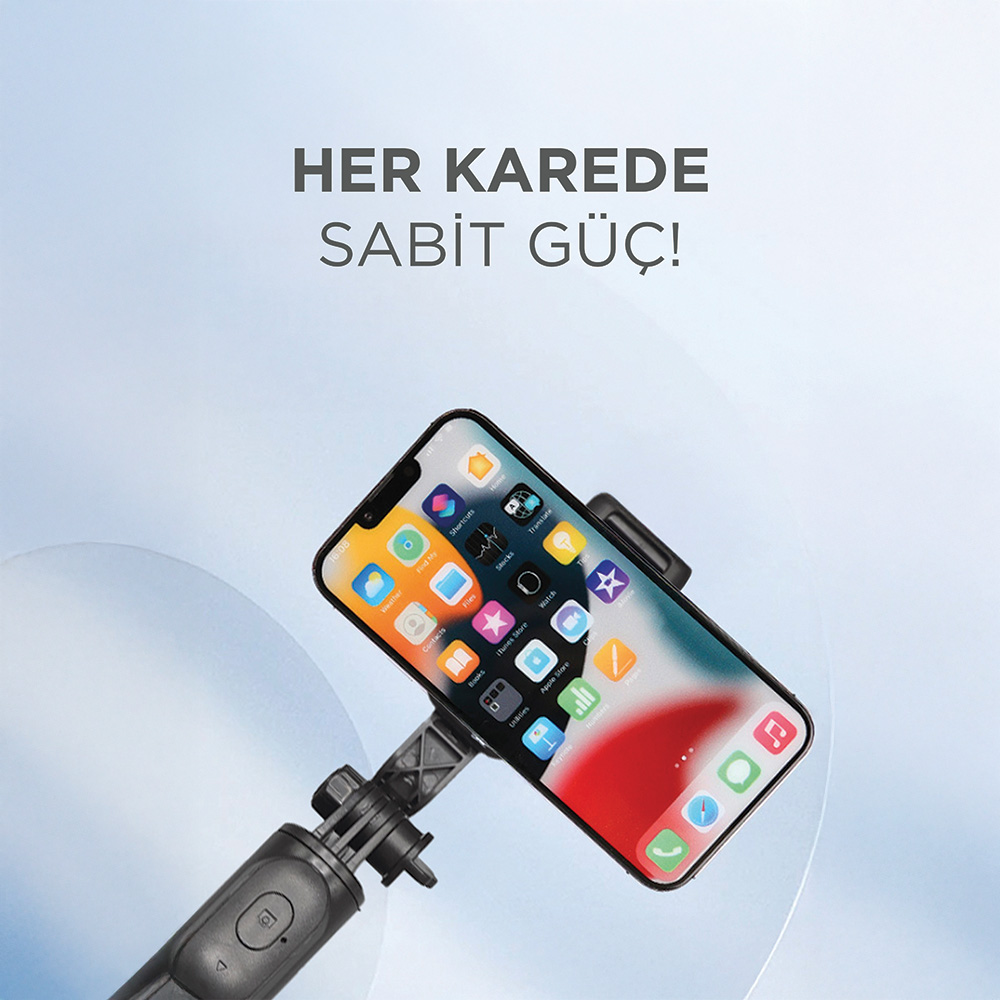 Bir akıllı telefon selfie çubuğuyla tutuluyor, ekranda uygulama simgeleri var.