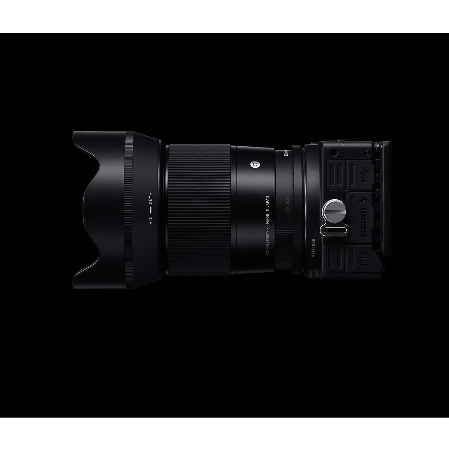 Una fotocamera nera con obiettivo, su sfondo nero.