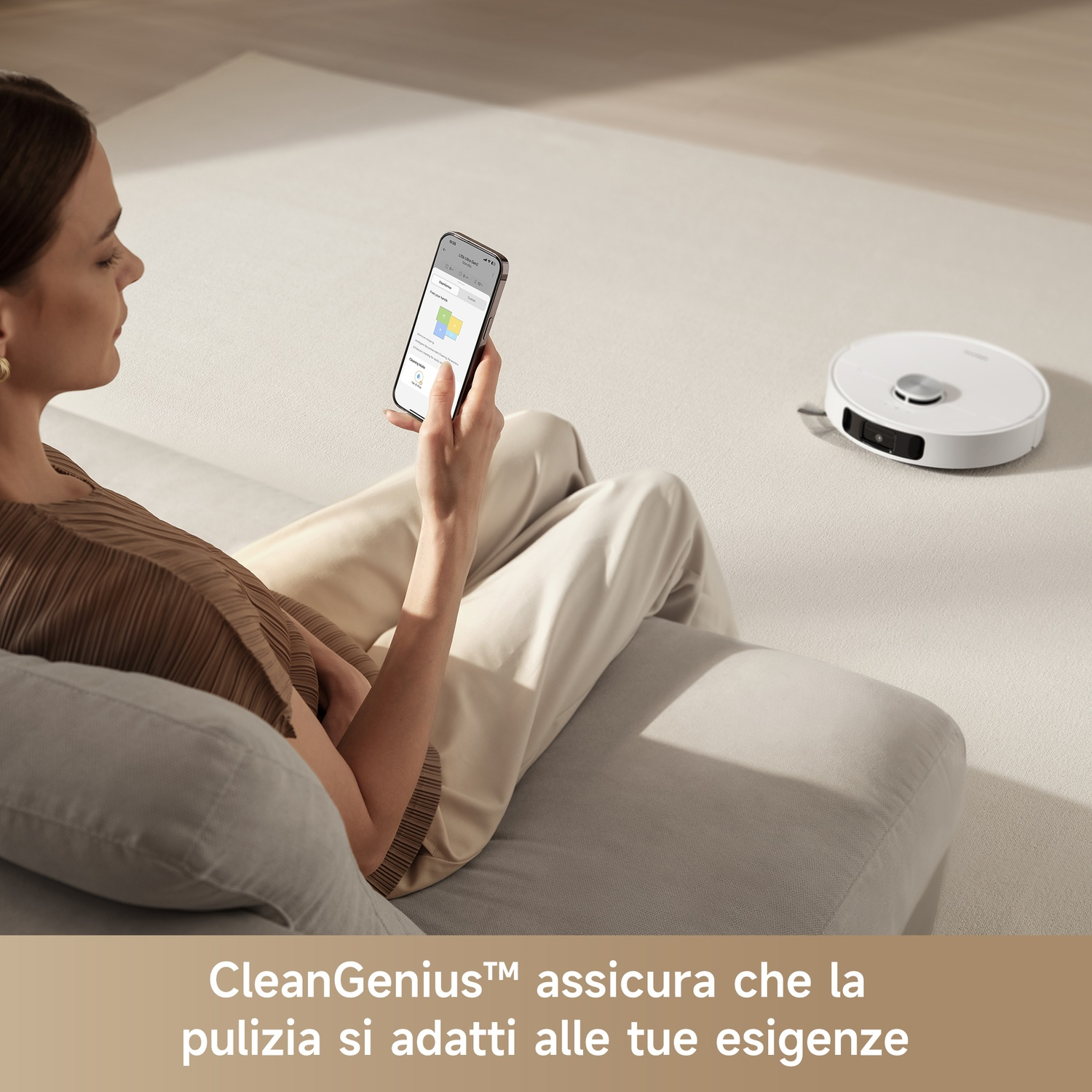 Una donna usa il suo smartphone per controllare un robot aspirapolvere su un tappeto chiaro.