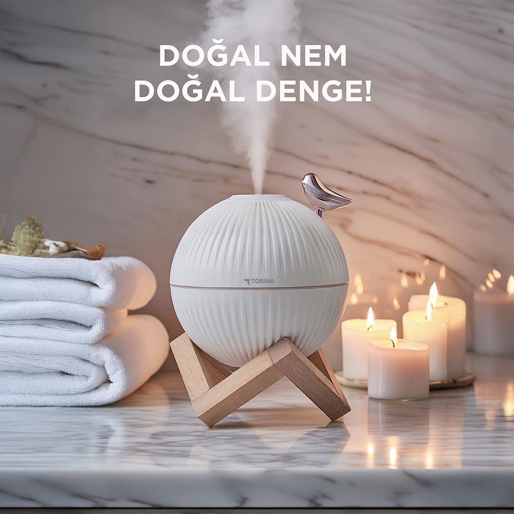 Kuşlu beyaz difüzör, havlu ve mumlar mermer üzerinde.