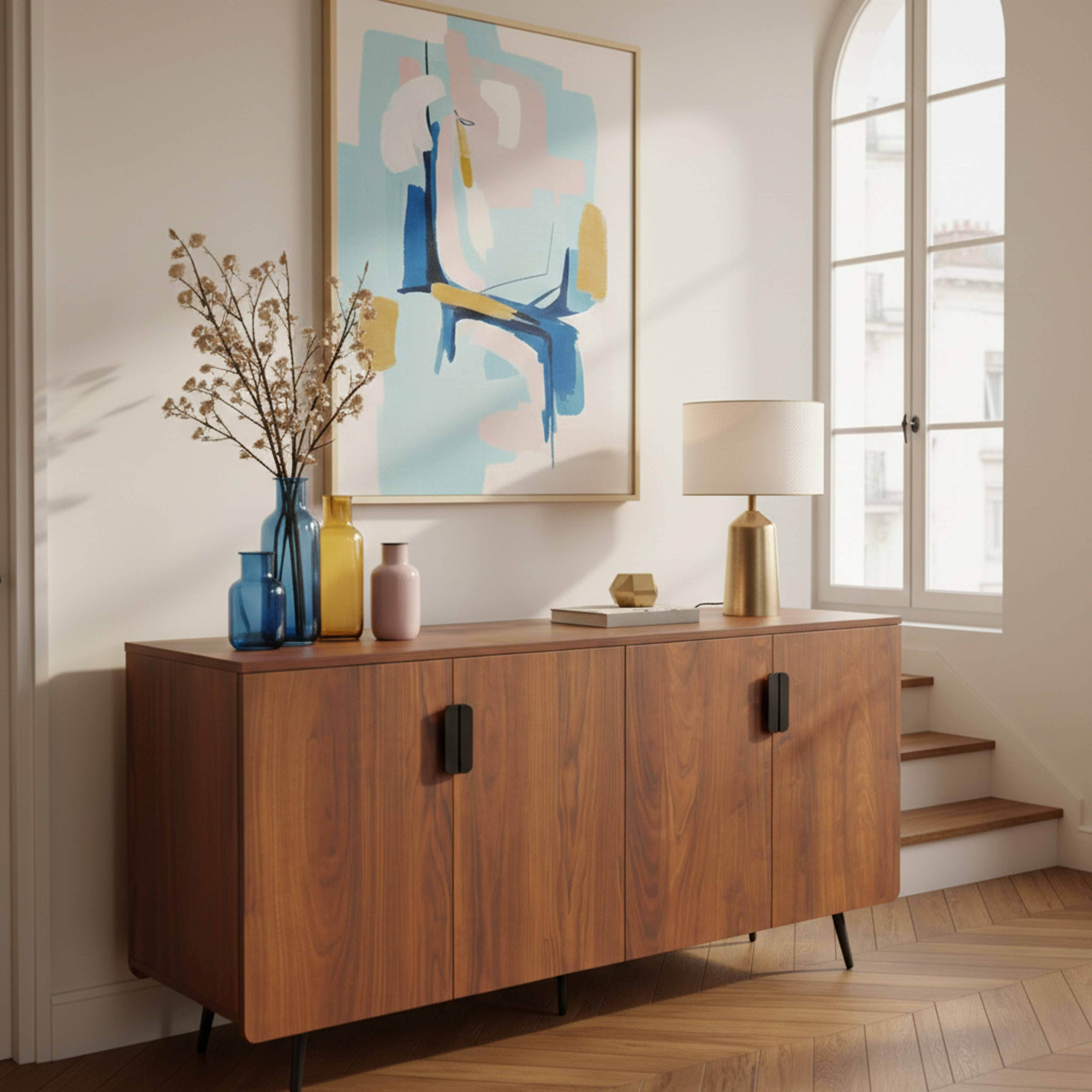 Ein hölzerner Schrank mit Vasen, Lampe und Kunstwerk vor einem Fenster.