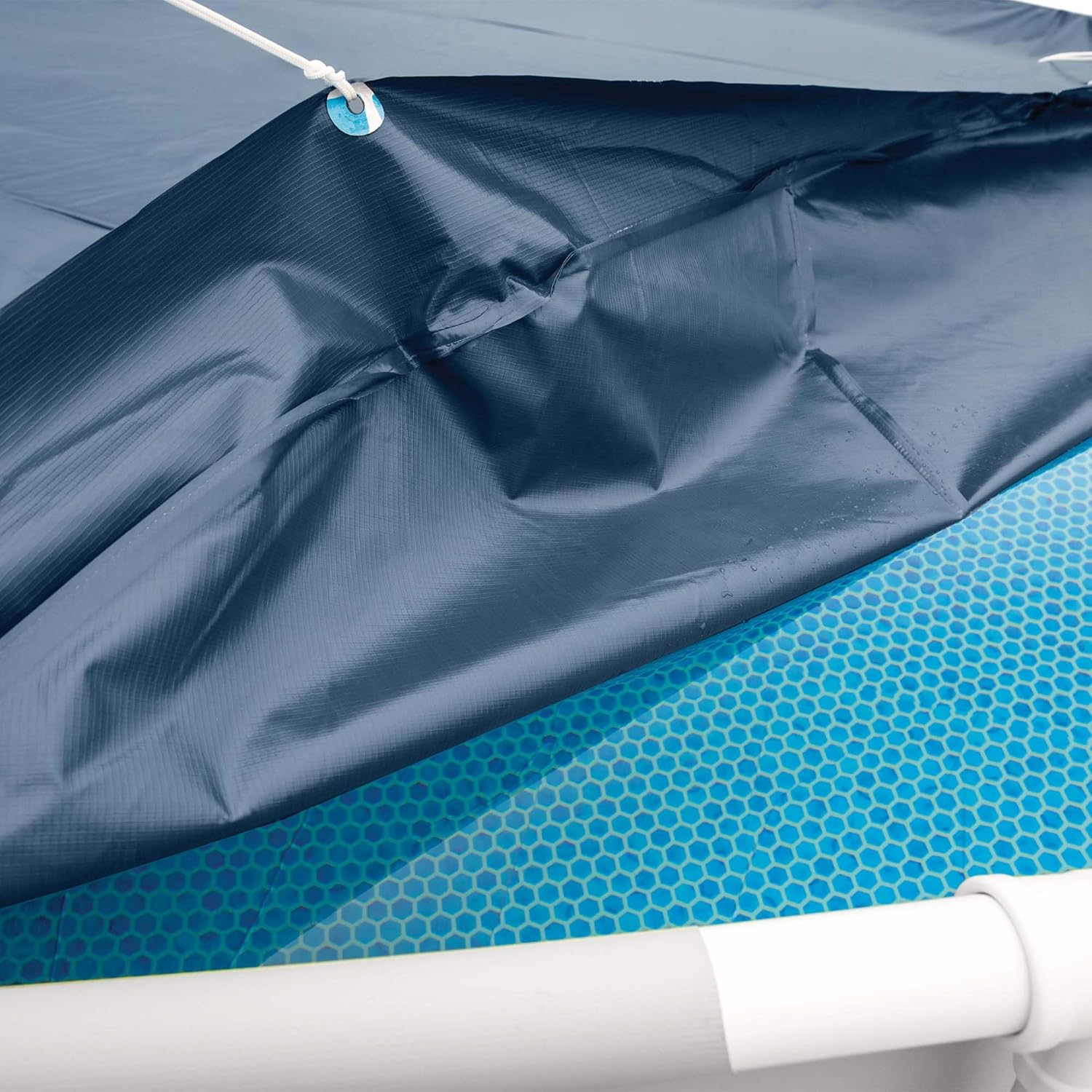 Ein blauer Poolabdeckung mit Seilen, die an Ösen befestigt sind.