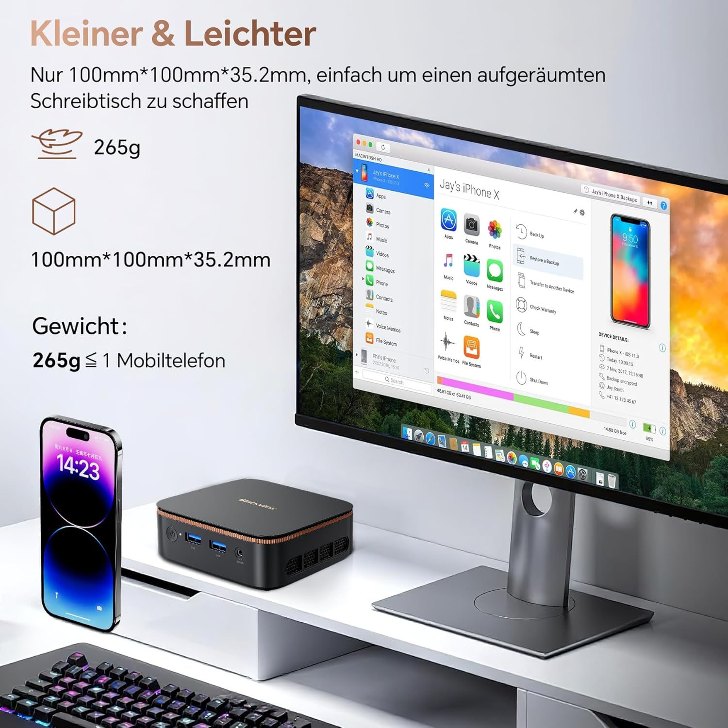 Ein kompakter schwarzer Mini-PC mit einem iPhone und Tastatur daneben.