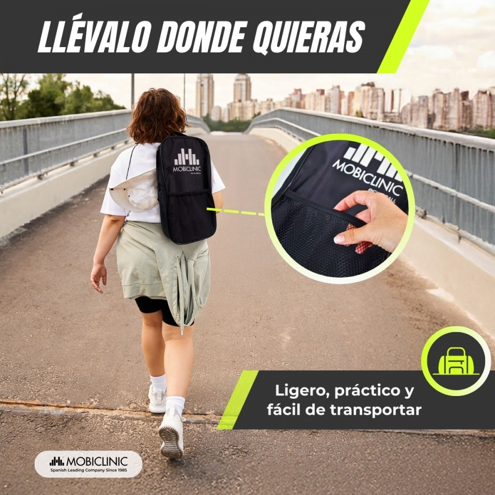 Una mujer camina por un puente con una mochila negra, ciudad al fondo.
