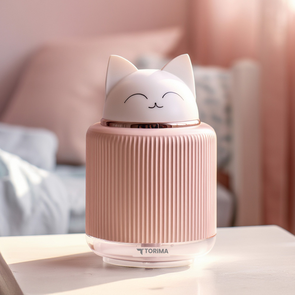 Pembe kedi şeklinde bir nemlendirici masanın üzerinde duruyor.