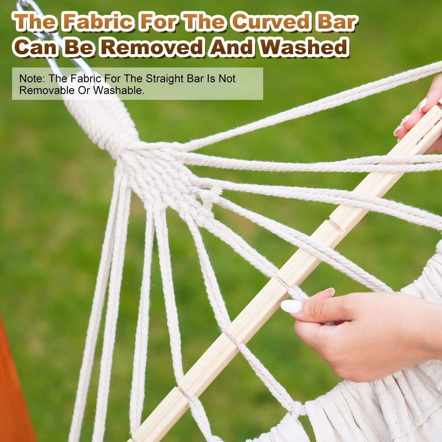 Dłoń reguluje białe liny na stojaku hamaka z zielonym tłem trawy.