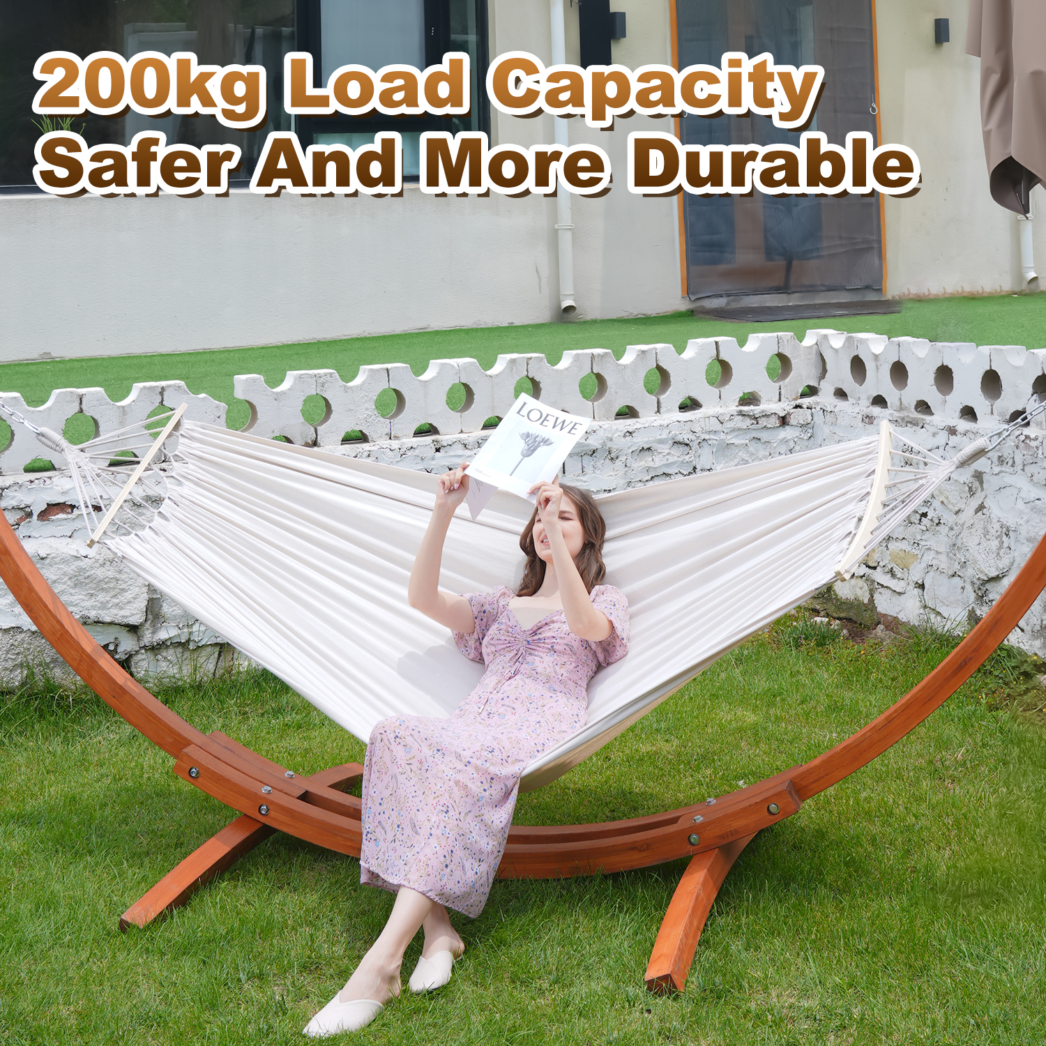 Kobieta czyta w hamaku na drewnianym stojaku w ogrodzie.