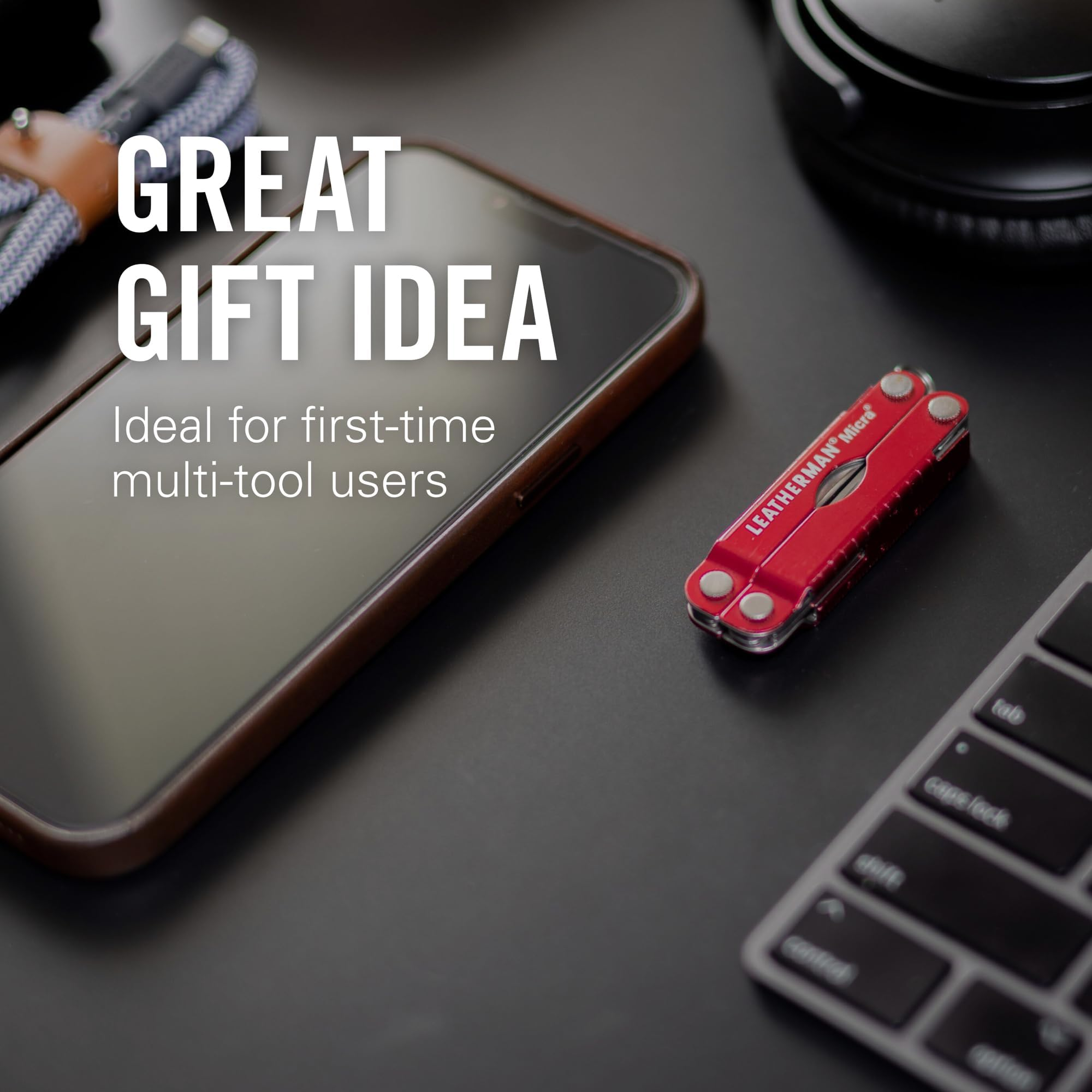 Ein rotes Leatherman Micra Multitool liegt neben einem Smartphone und einer Tastatur.