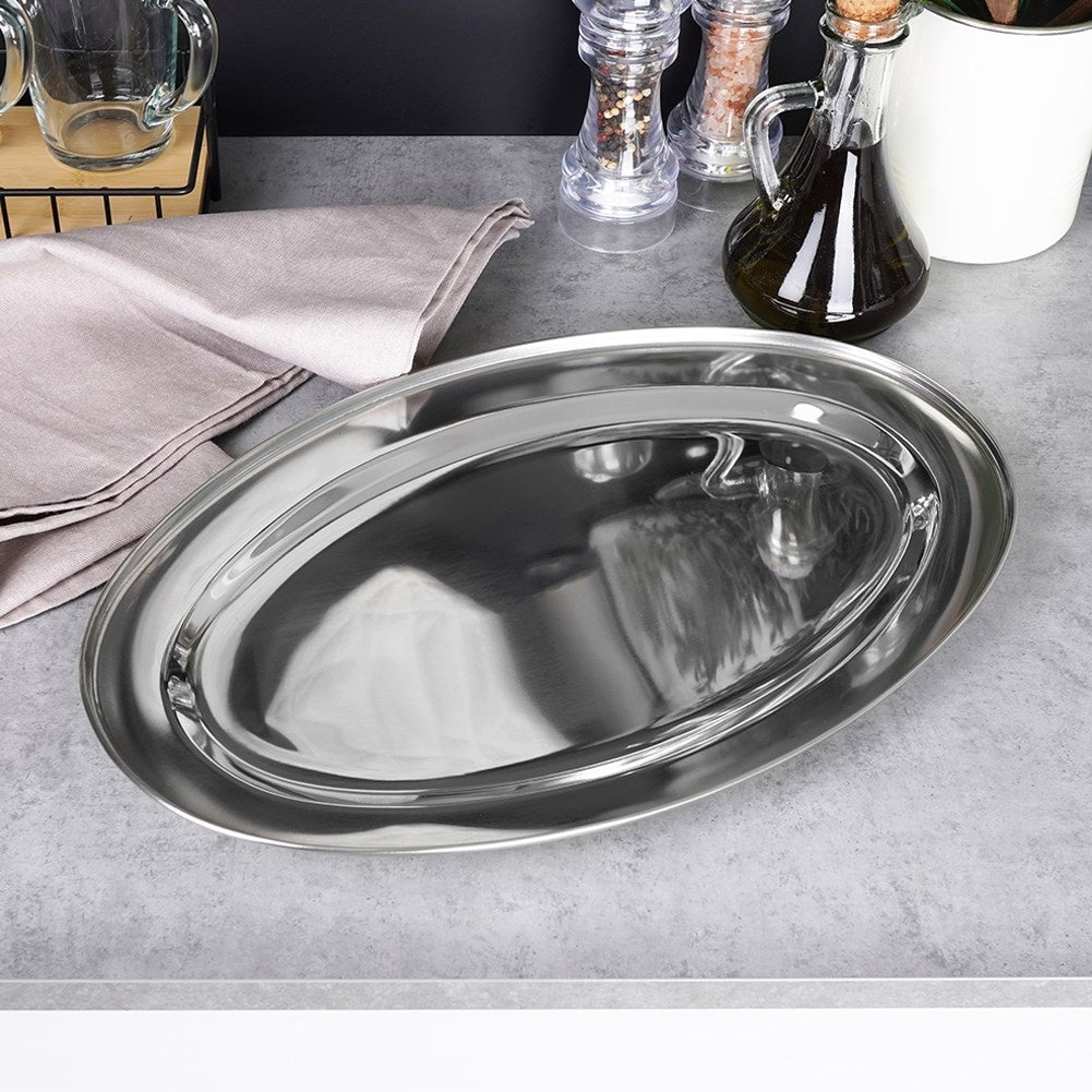 Una bandeja ovalada de metal brillante se encuentra sobre una encimera gris.