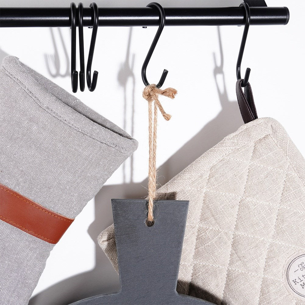 Manopla gris, tabla de cortar gris, bolsa de tela gris cuelgan de ganchos.