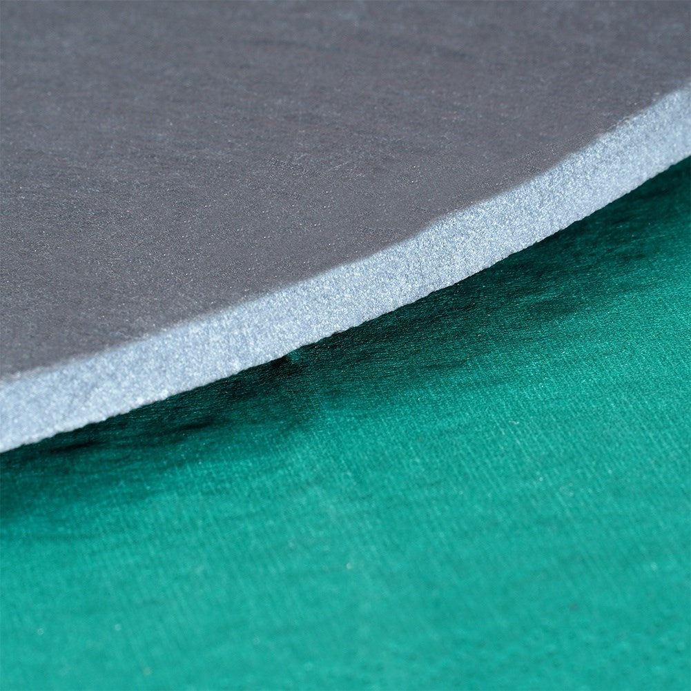 Una alfombra gris descansa sobre una superficie de tela verde texturizada.