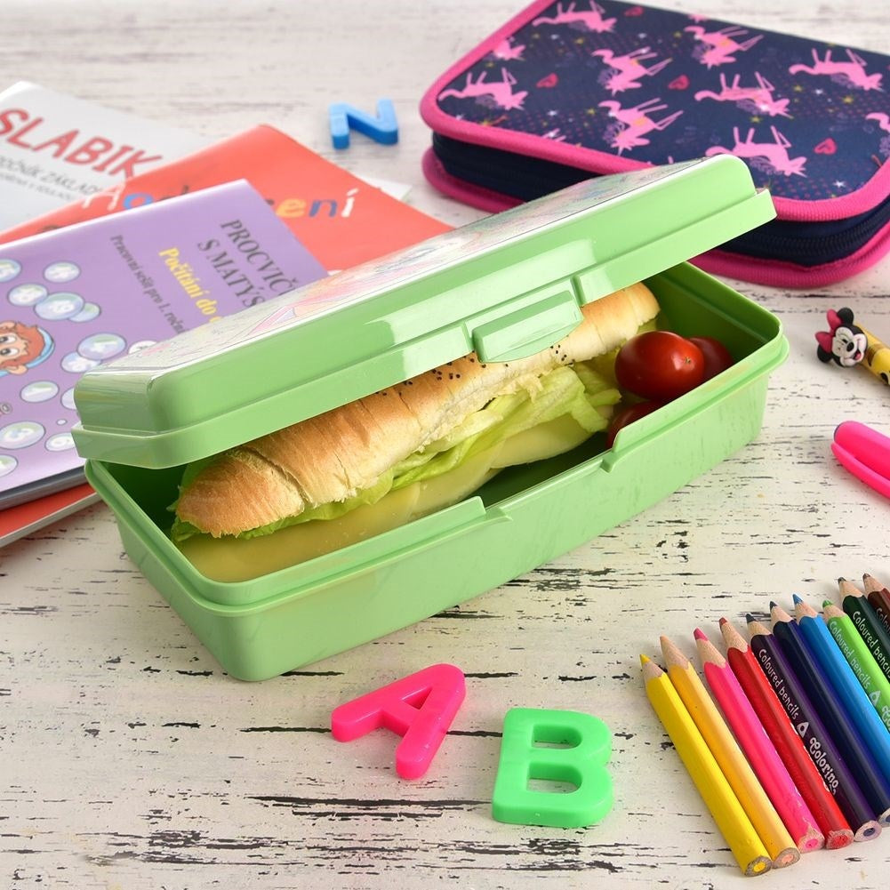 Fiambrera verde con sándwich, lápices de colores, libros y estuche.