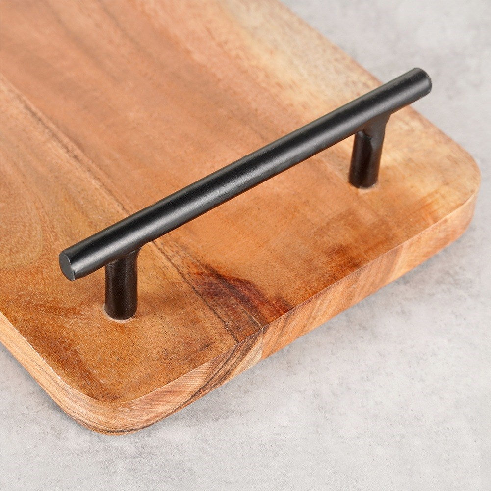 Un vassoio rettangolare in legno con manico nero su una superficie di cemento.