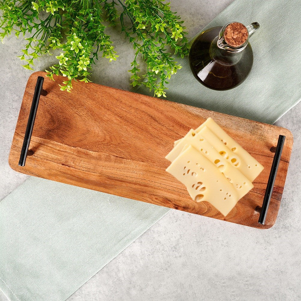 Tagliere in legno con fette di formaggio, bottiglia di olio d'oliva e rametti verdi.