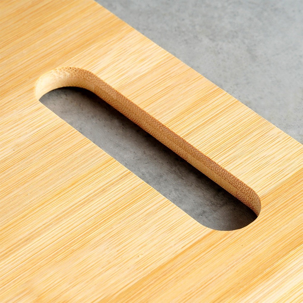 Tabla de cortar de madera con ranura sobre fondo gris.