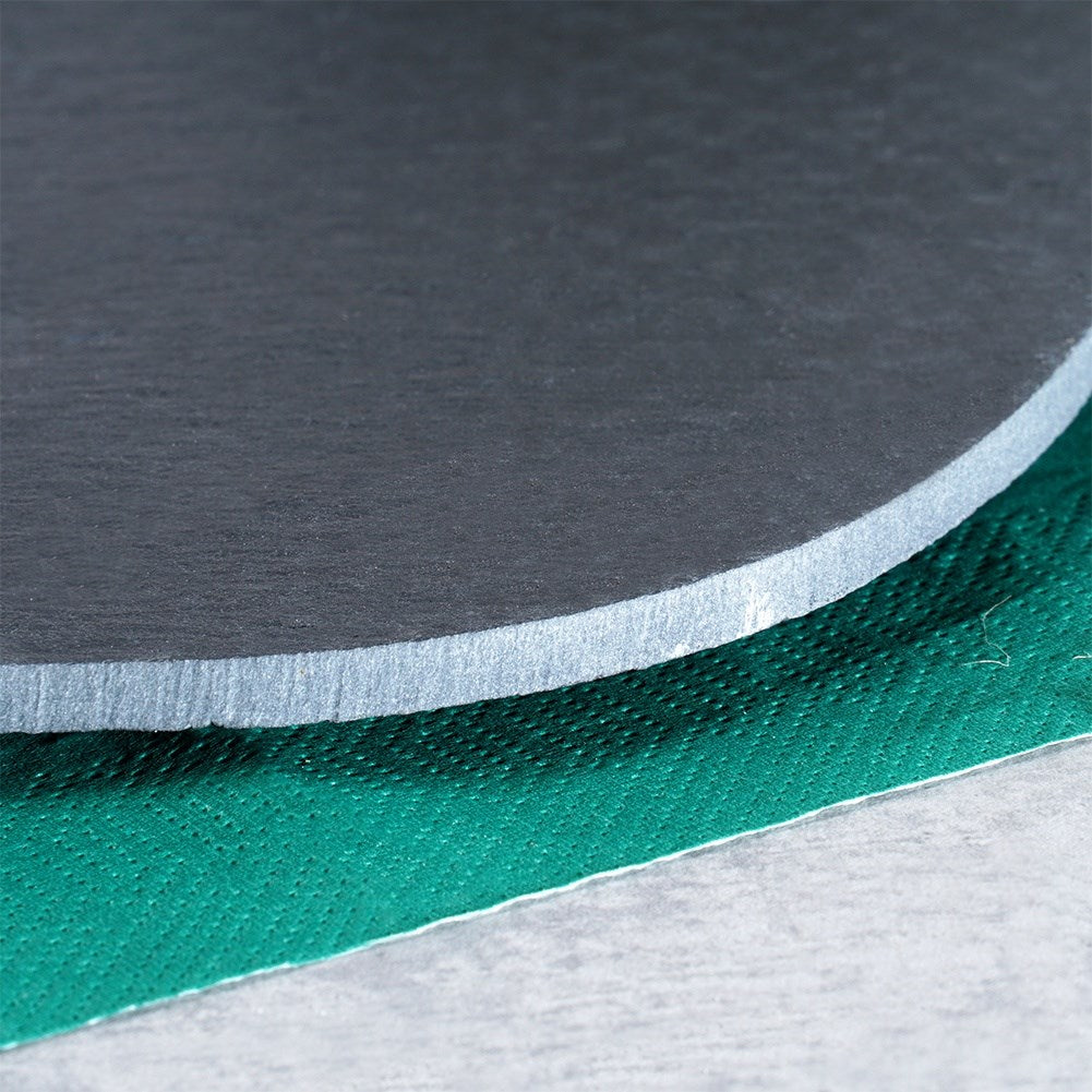 Tres materiales superpuestos: disco gris oscuro, borde blanco y superficie texturizada verde.