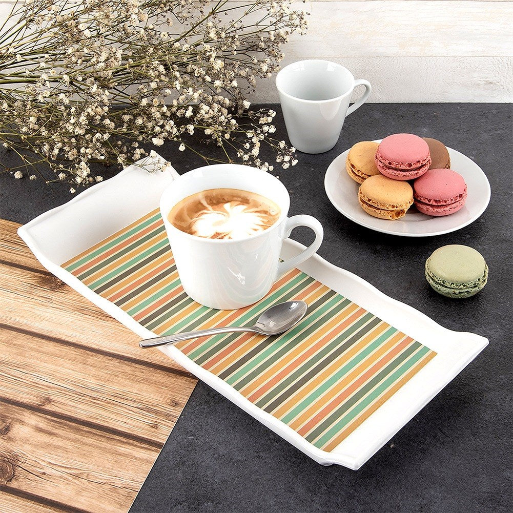 Una taza de café con latte art, macarons y un pequeño jarrón con flores.