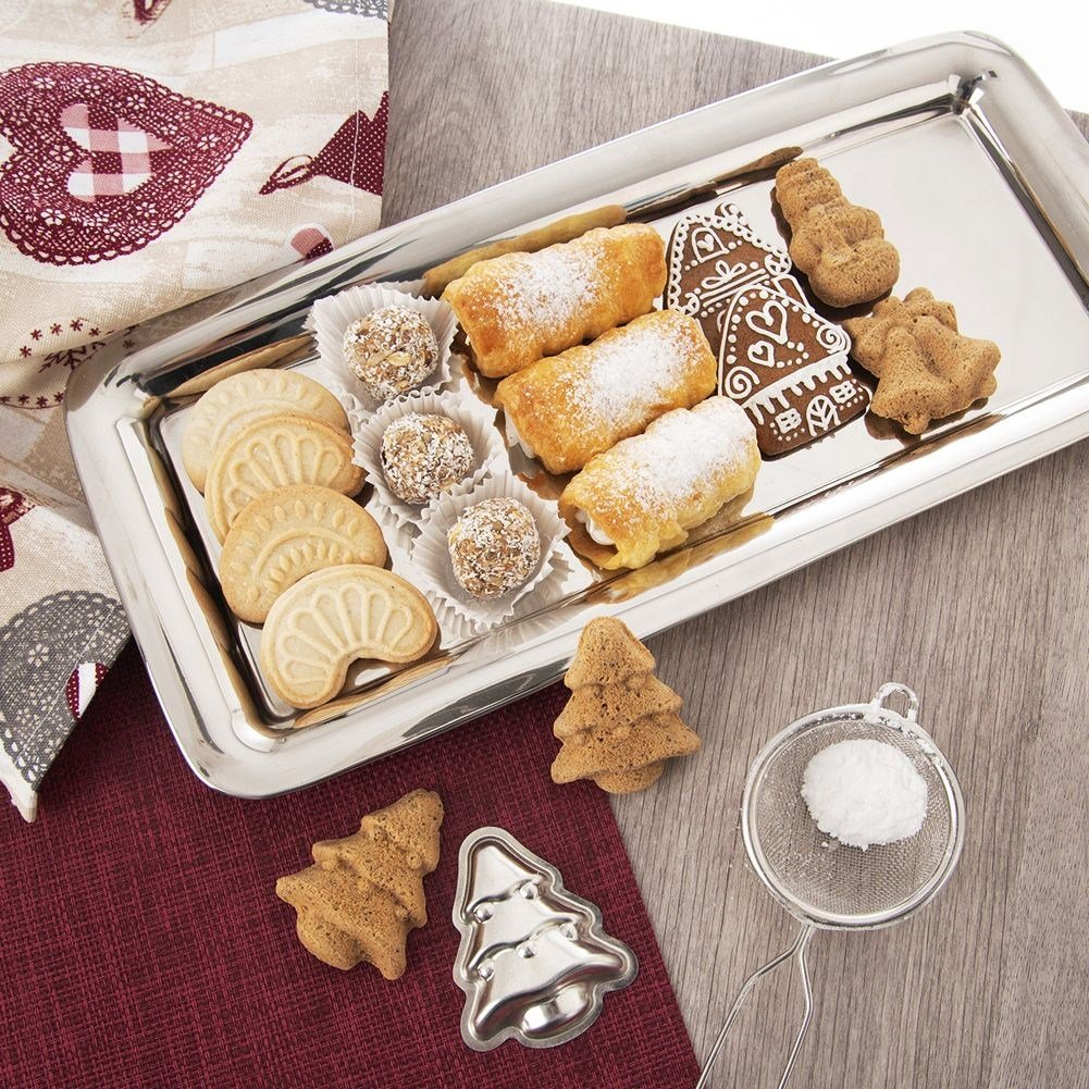 Bandeja plateada con dulces navideños: galletas, cannoli, casa de jengibre y trufas.