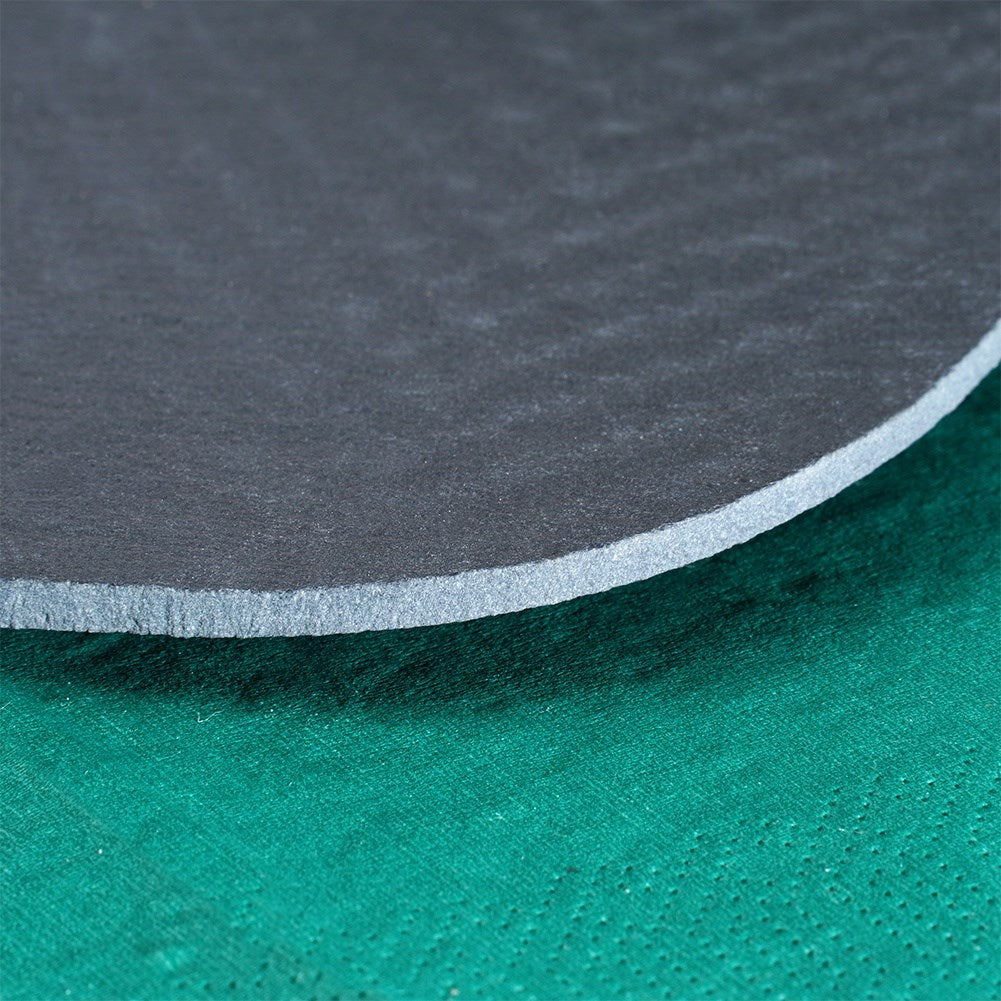 Disco gris con borde texturizado sobre tela verde.