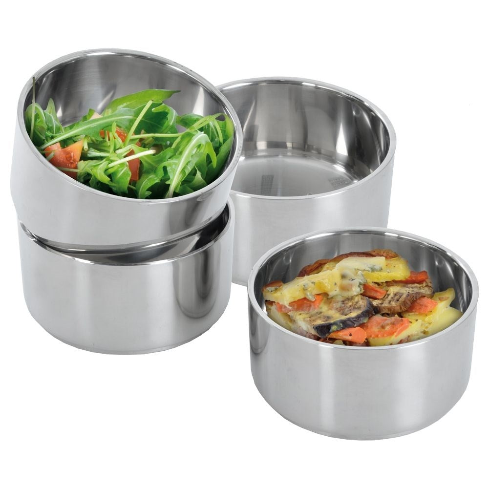 Tres cuencos de acero inoxidable: uno con ensalada, uno con guiso, uno vacío.
