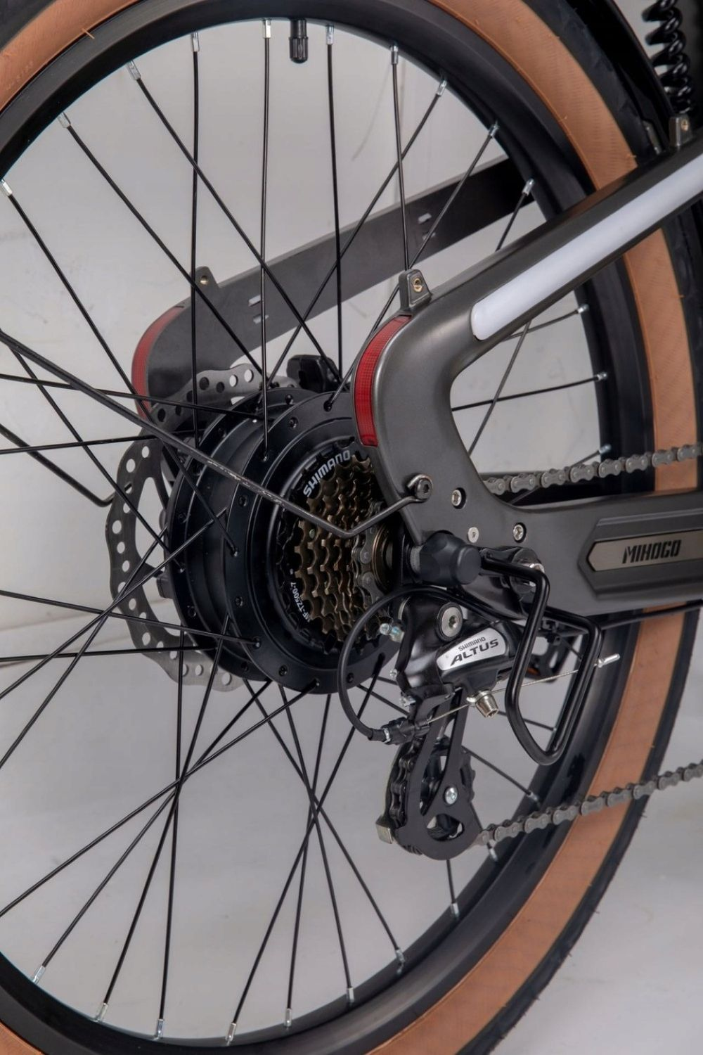 Primer plano de la rueda trasera de una e-bike, mostrando el cambio, disco y buje.
