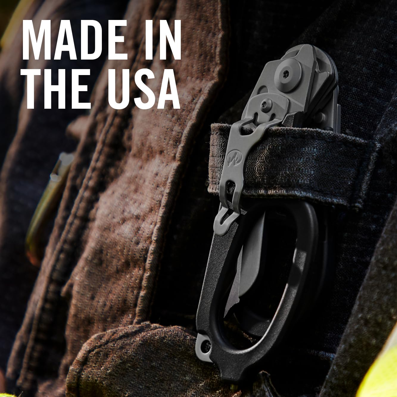 Ein graues Multitool mit schwarzem Griff ist an einer Jeans befestigt. Text: MADE IN THE USA.