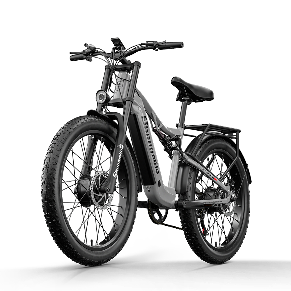 Graues E-Bike mit dicken Reifen, Federung und Gepäckträger, Vorderansicht.
