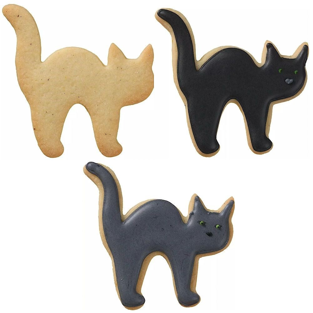 Tres galletas con forma de gato: una natural, una negra y una gris.