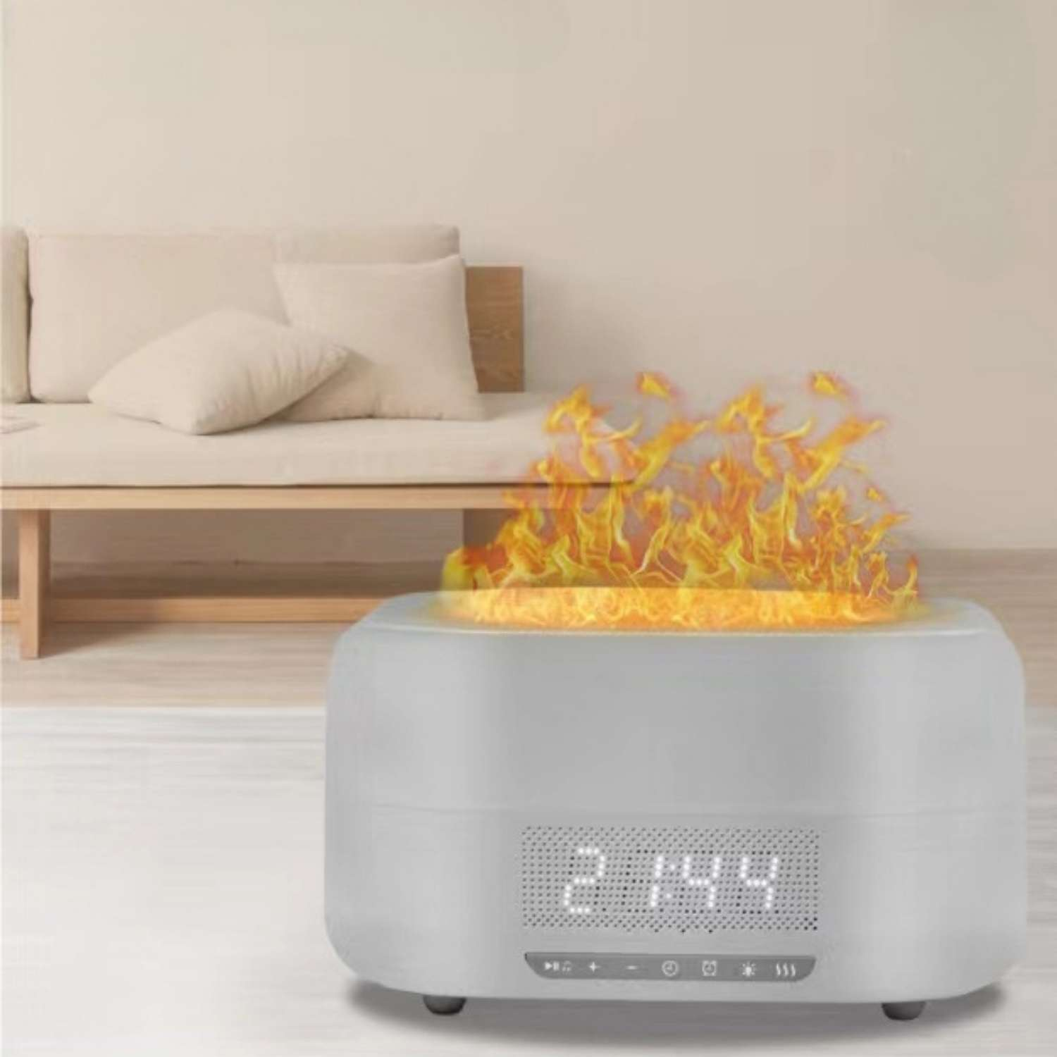 Grauer Diffusor mit Flammen-Effekt und digitaler Uhrzeit auf einem Sofa.