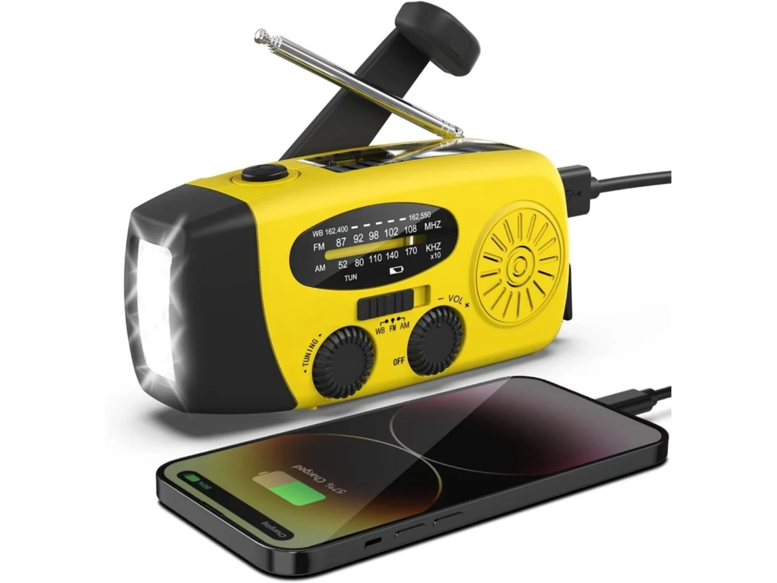 Eine gelbe Kurbelradio mit einer hellen Taschenlampe und einem aufgeladenen Smartphone daneben.