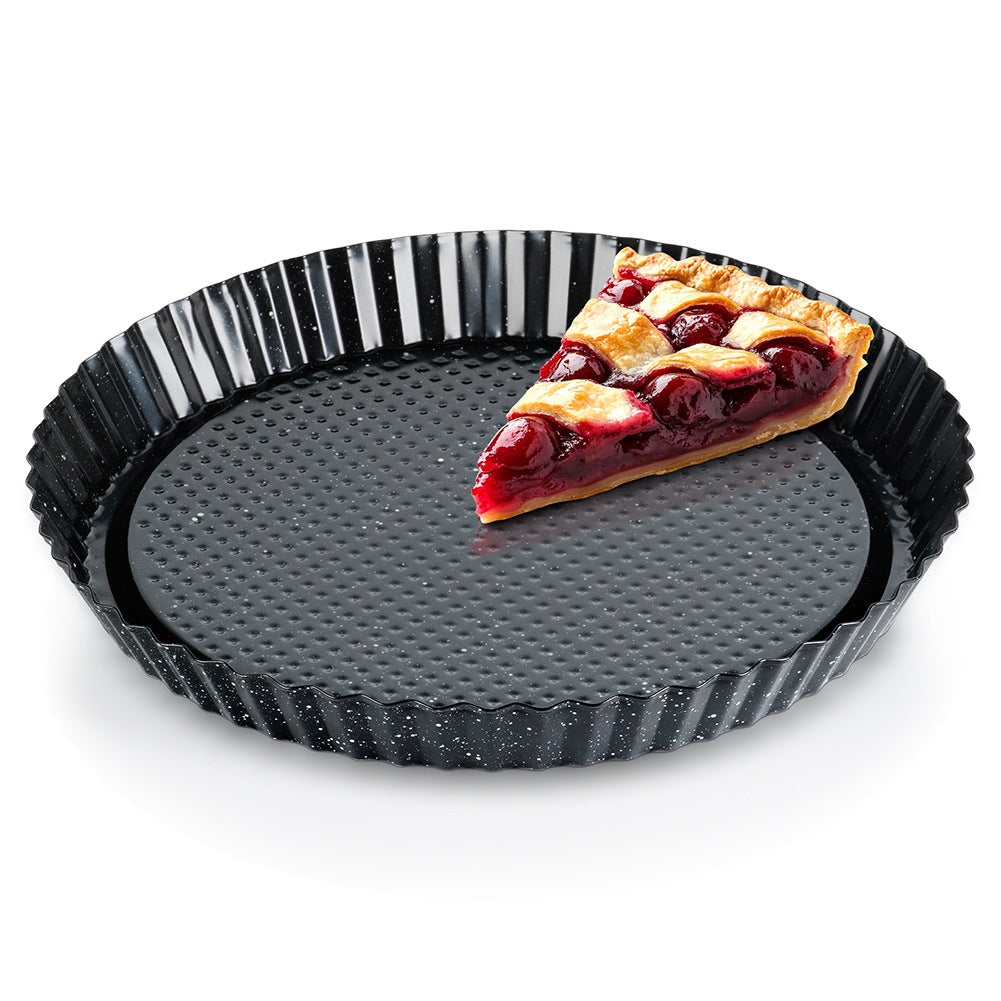 Una rebanada de pastel de cereza en un molde negro acanalado.