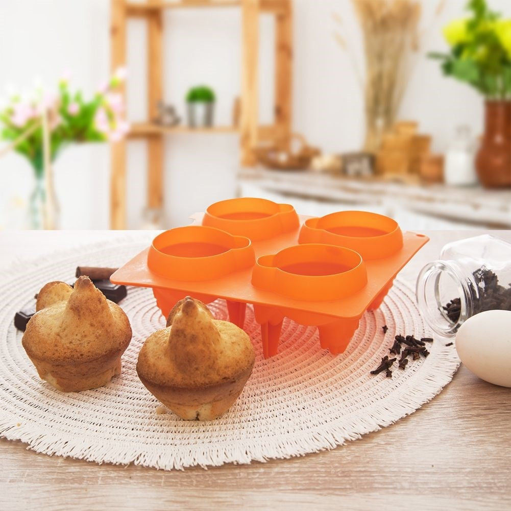 Molde de repostería naranja con cuatro cavidades redondas, al lado dos magdalenas, chocolate y especias.