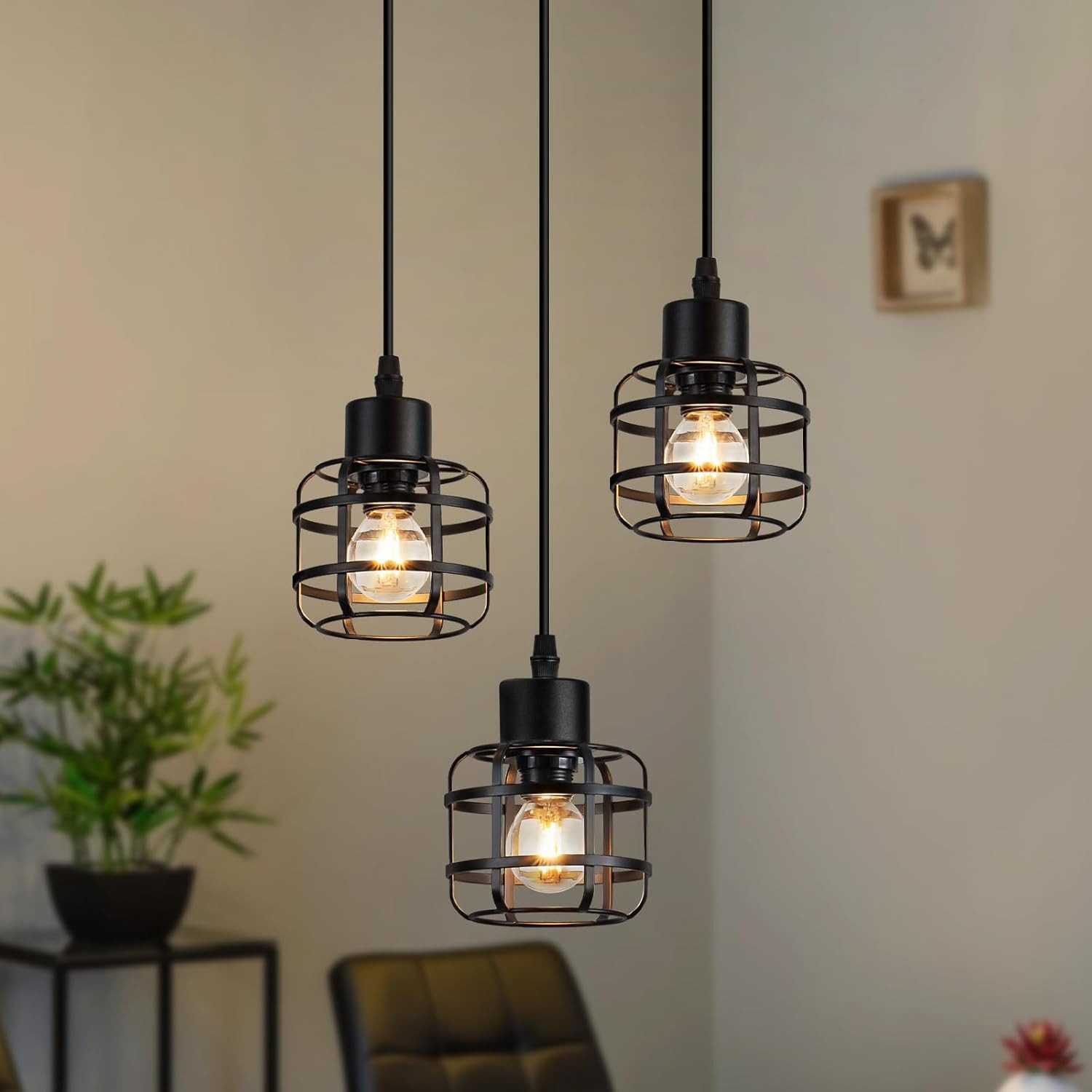 Tre lampade a sospensione nere con paralumi a gabbia e lampadine visibili.