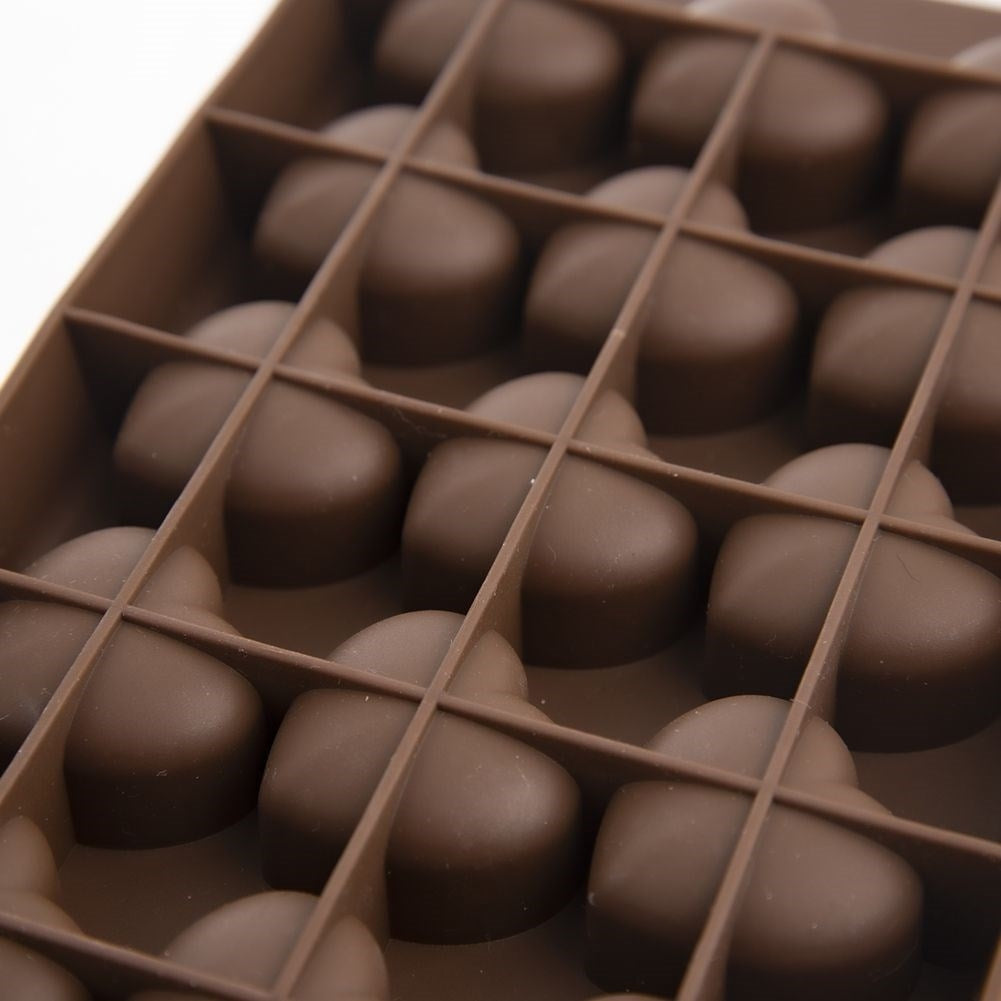 Corazones de chocolate marrones en un molde.