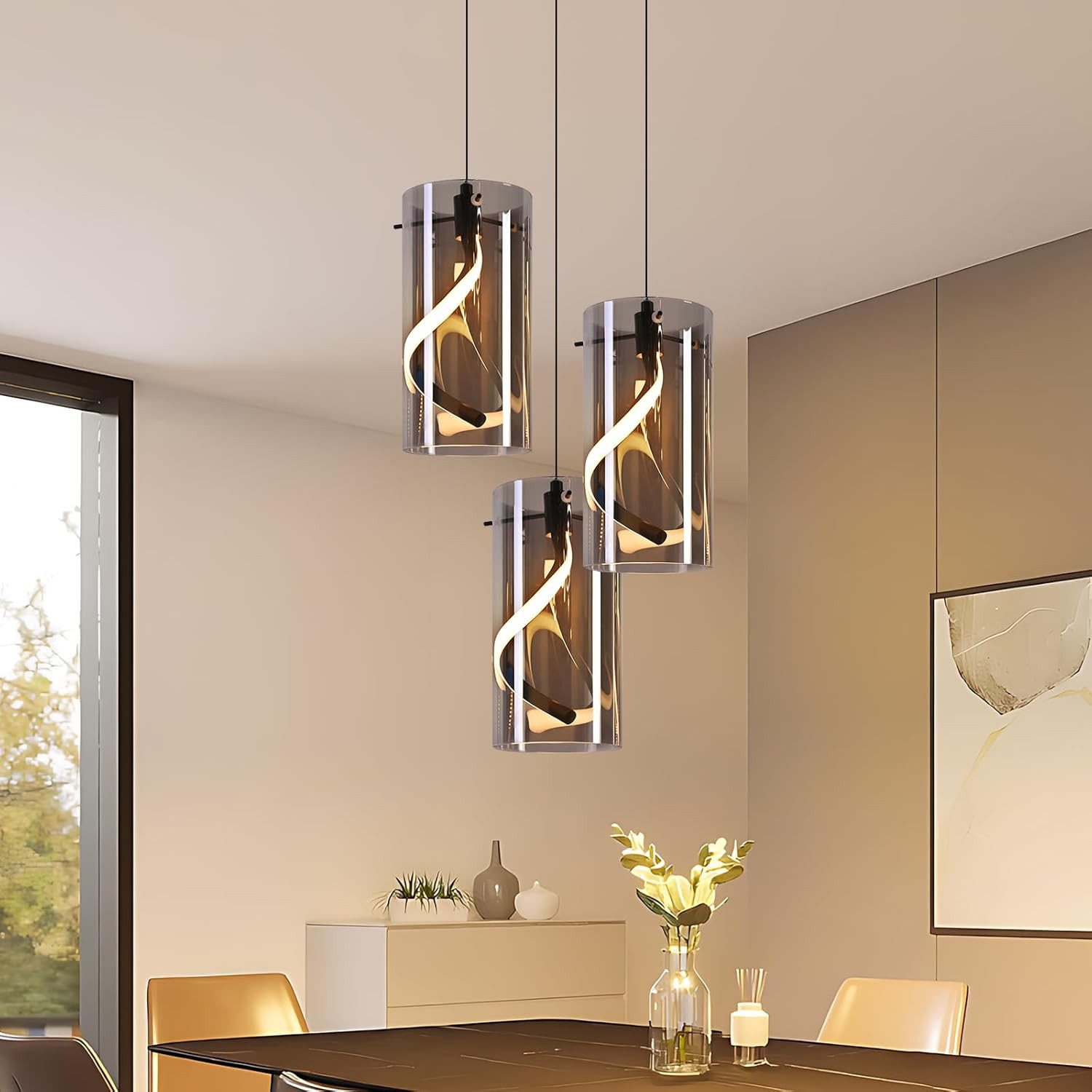 Tre lampade a sospensione cilindriche con design a spirale all'interno sopra un tavolo da pranzo.