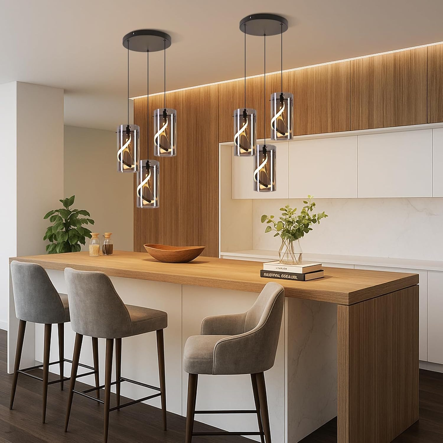 Cucina moderna con bancone, sgabelli e lampade a sospensione cilindriche.