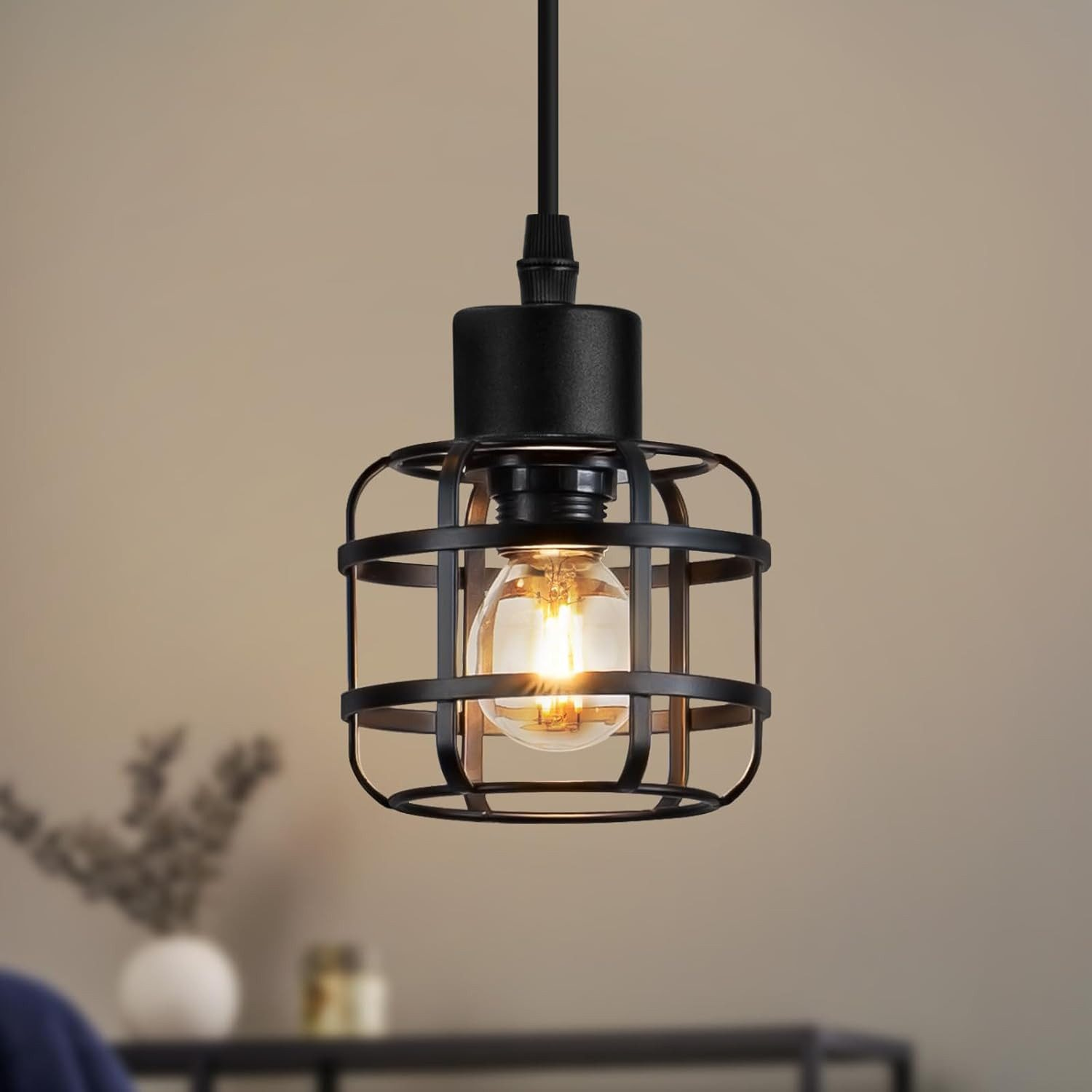 Lampada a sospensione nera con design a gabbia e lampadina.