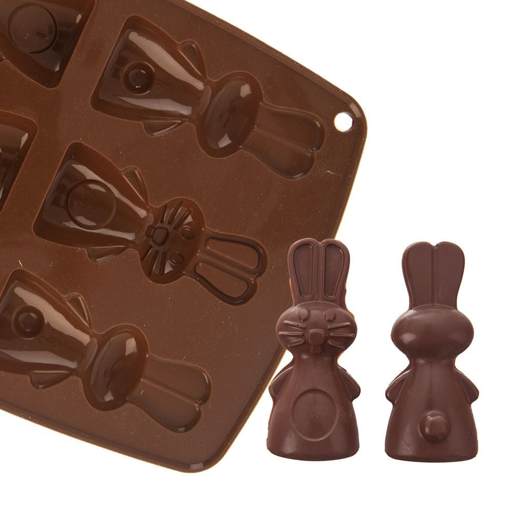 Molde de chocolate marrón con forma de conejito y dos conejitos de chocolate.