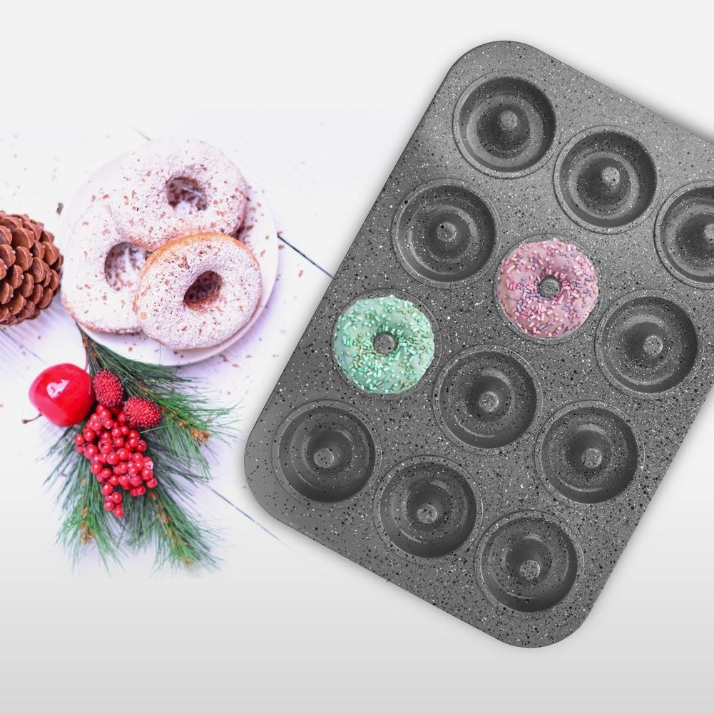 Molde para donuts con dos donuts decorados y tres donuts espolvoreados al lado.