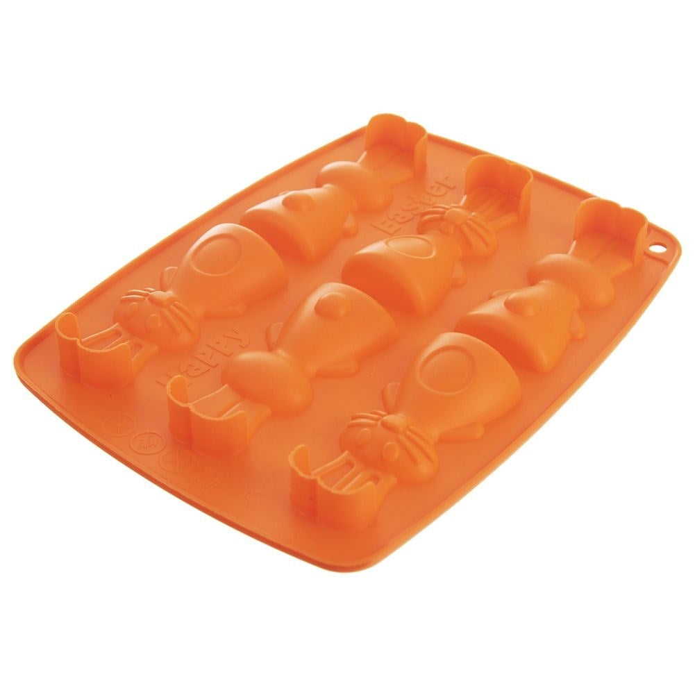 Un molde de silicona naranja para chocolate con diseños de conejitos y zanahorias.