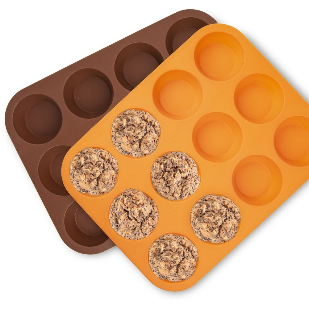 Moldes para muffins marrones y naranjas con muffins horneados.