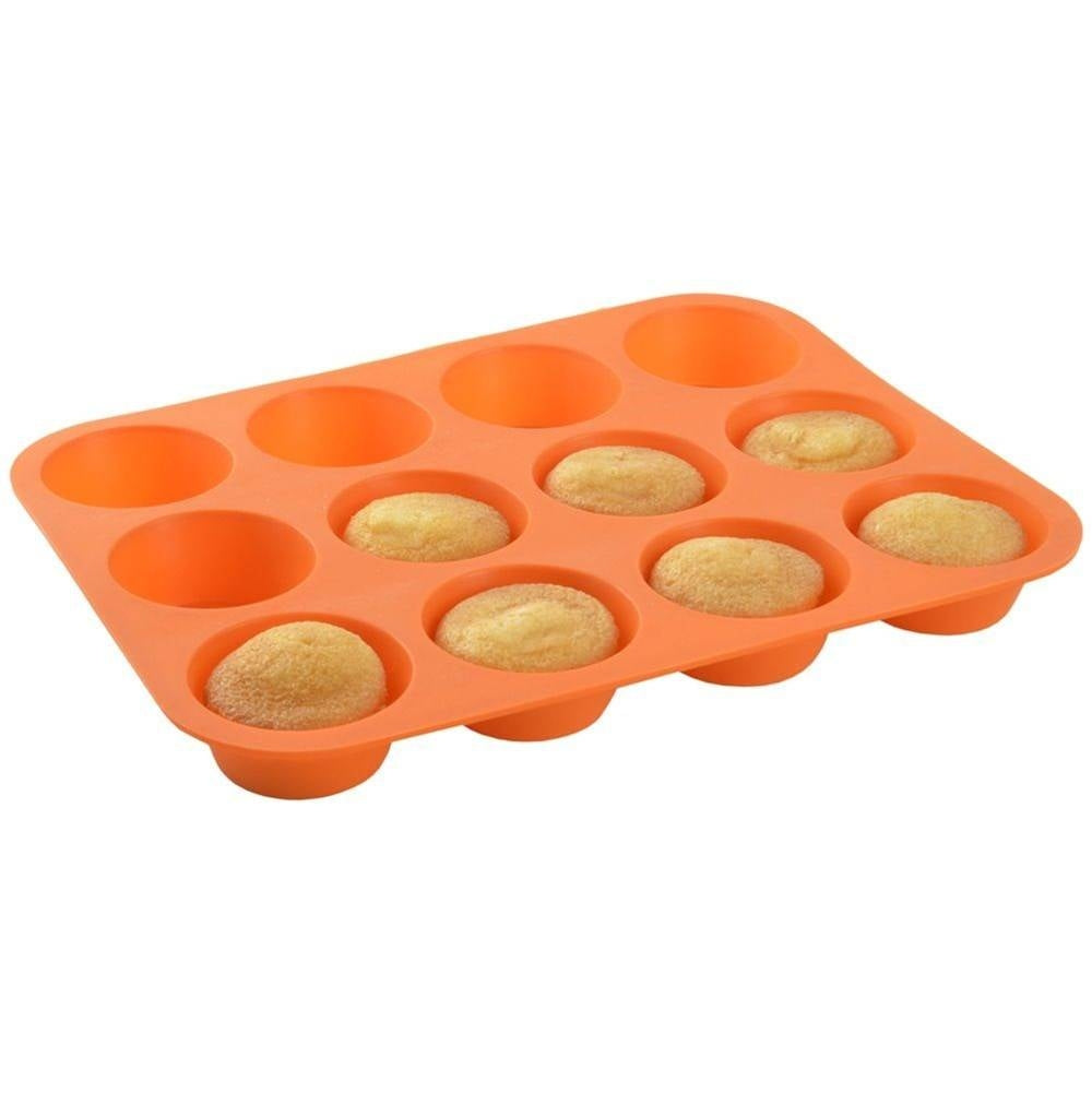 Un molde para muffins de silicona naranja con 12 cavidades, algunas con pequeños muffins.