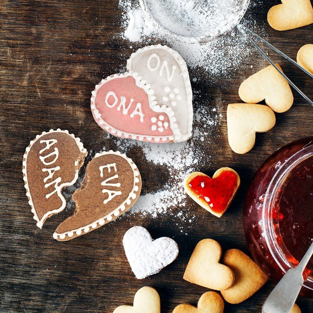 Galletas en forma de corazón con nombres y un tarro de mermelada.